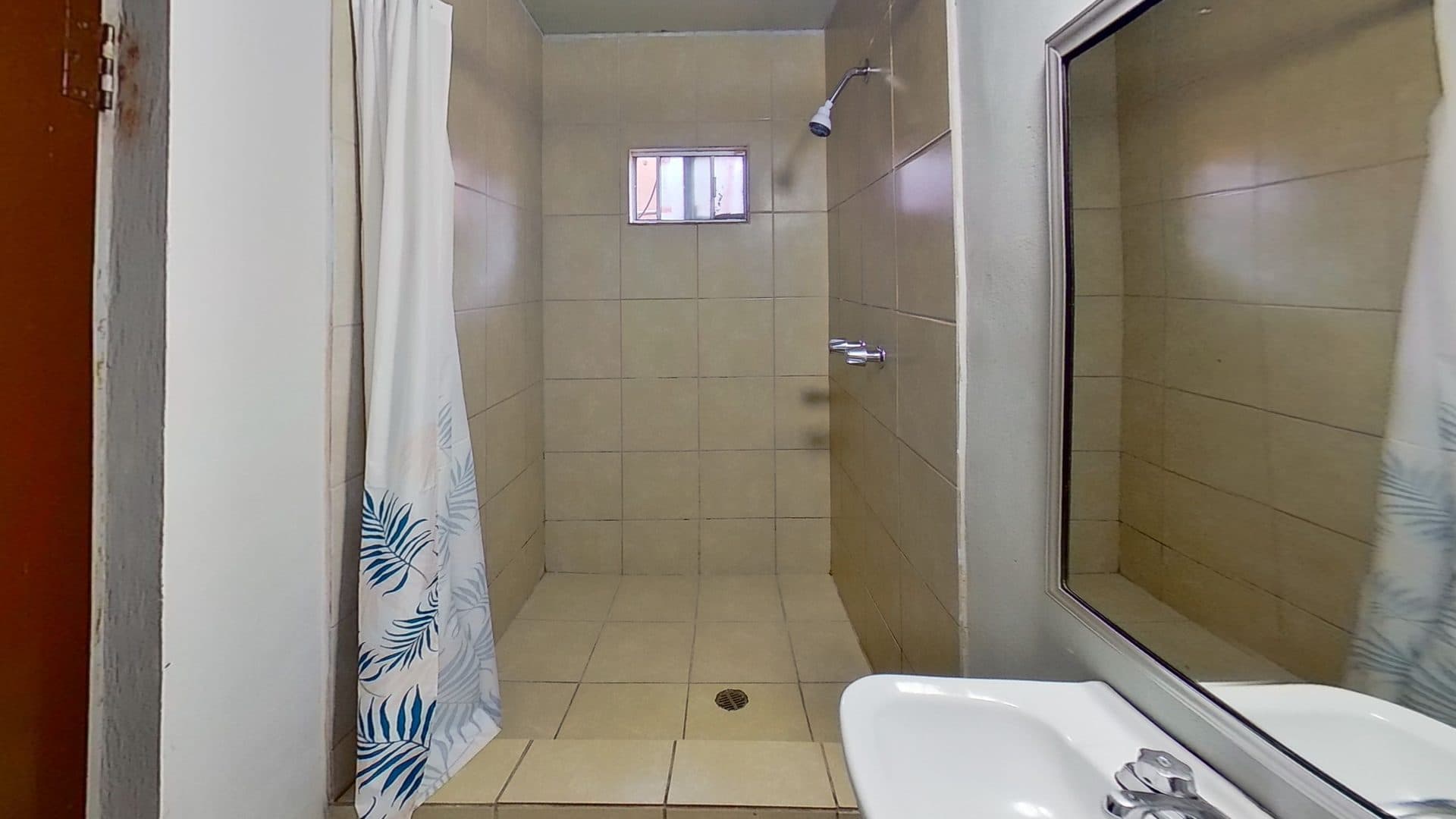 Baño con regadera y lavabo de la habitación doble