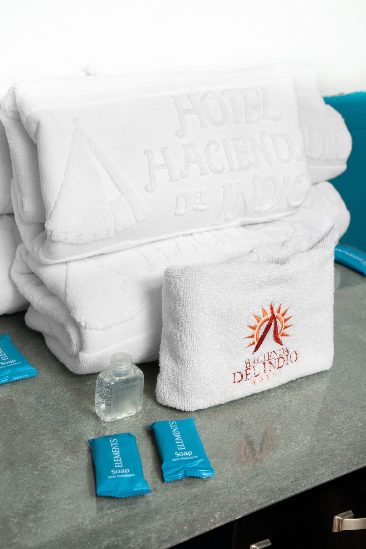 Toallas blancas con el logotipo bordado y amenidades de baño
